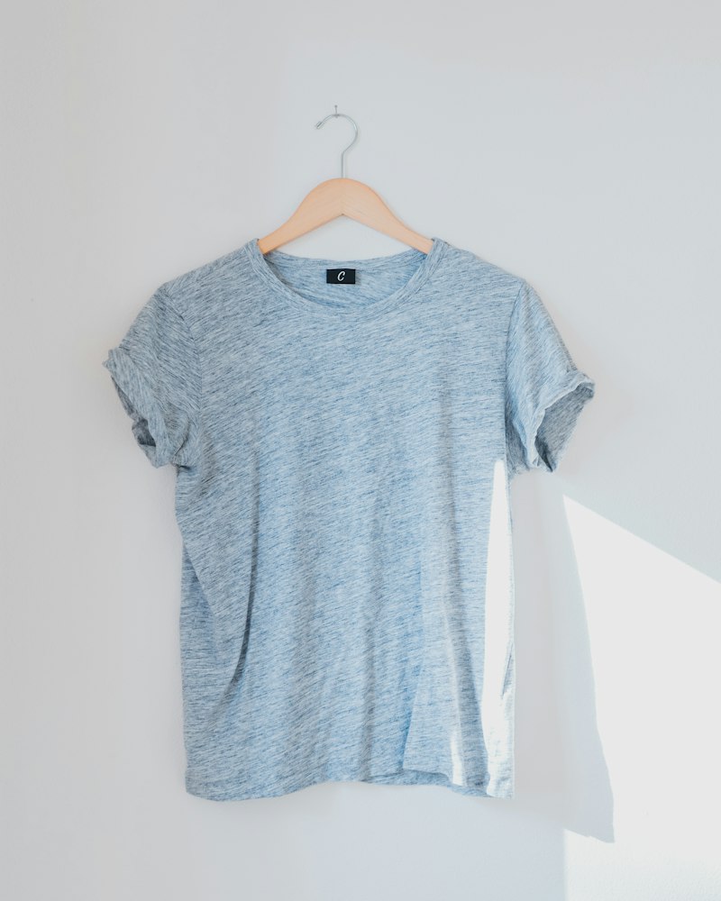 A grey t-shirt hanging on a wall